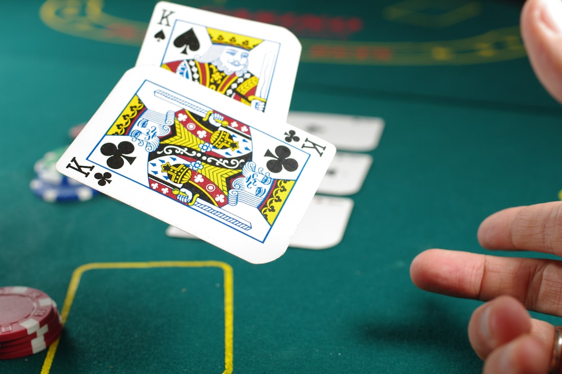 Chip poker bertumpuk di atas meja hijau